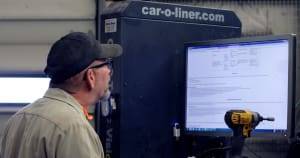 Technician using Car-O-Liner computerized measuring system for precise vehicle frame alignment at Barry's Paint Shop.