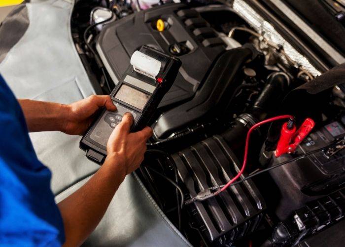 man with a diagnostic tester deviec for car