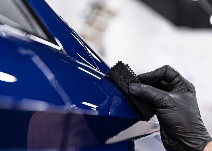 A gloved hand polishes a shiny
