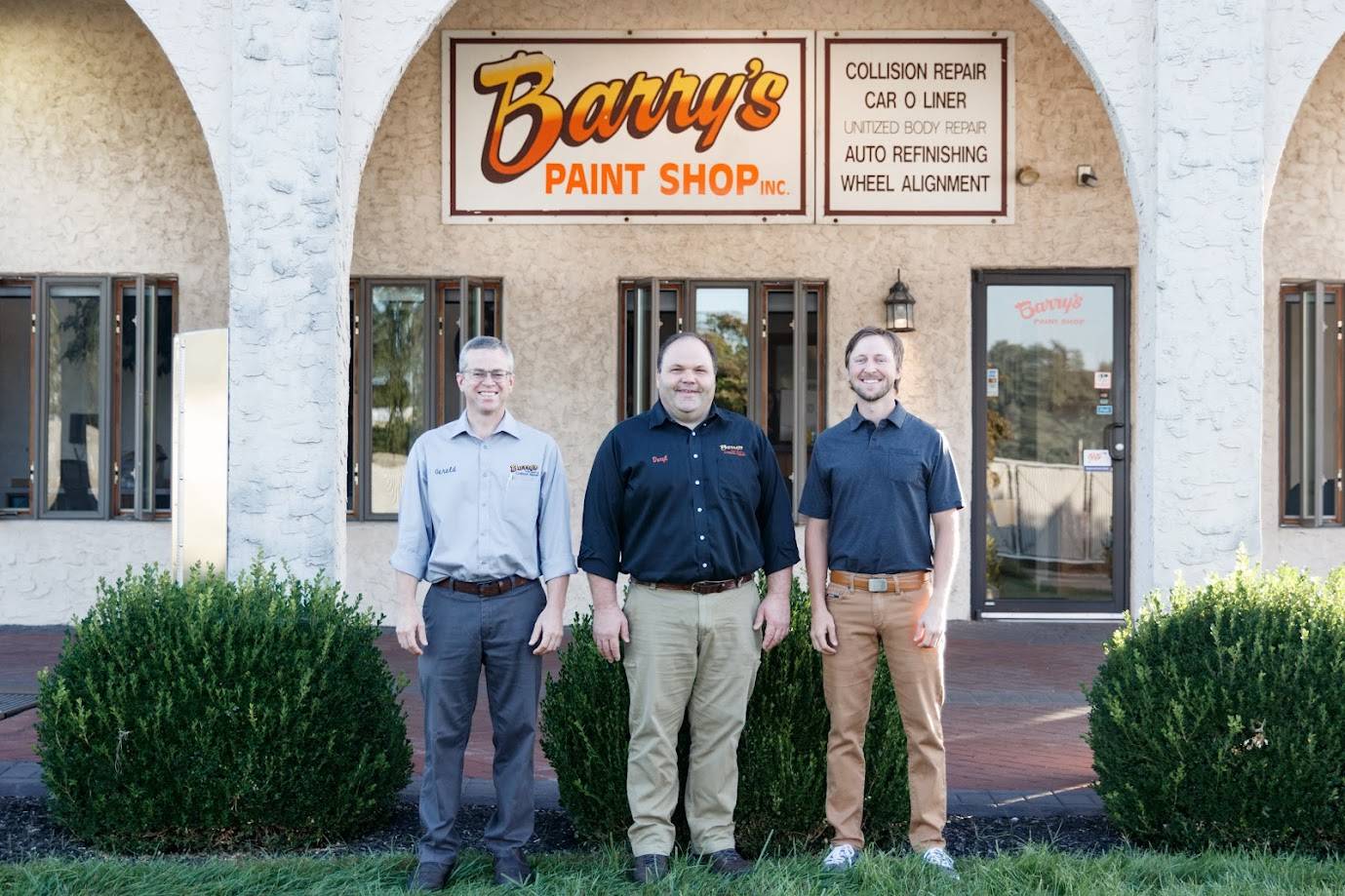 Owners of Barry's Paint Shop standing in front of the business, showcasing their commitment to quality collision repair and customer service.