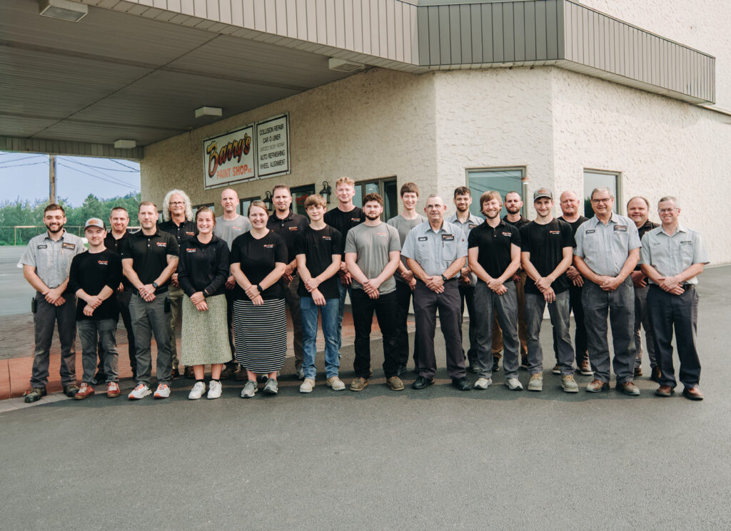 Barry's Paint Shop team members in front of the collision repair shop, demonstrating commitment to quality service and over 300 years of automotive repair experience.
